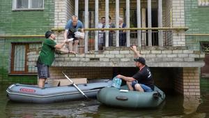 Los voluntarios entregan alimentos a los residentes locales en un área inundada, en medio del ataque de Rusia a Ucrania, en Kherson