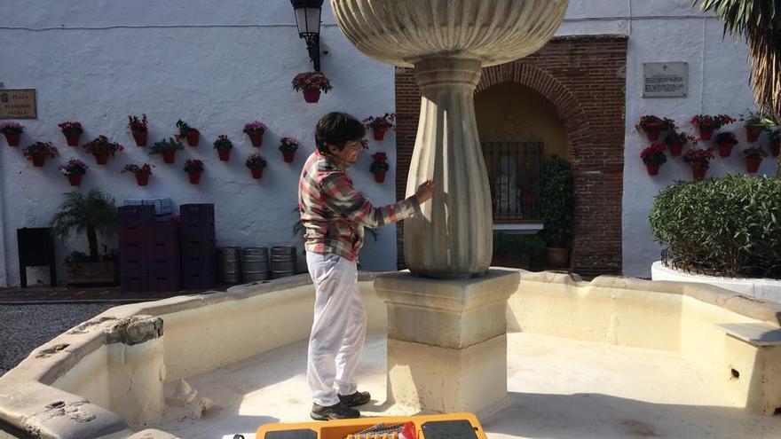 La restauradora Estrella Arcos von Haartman trabaja sobre la fuente de la plaza de los Naranjos.