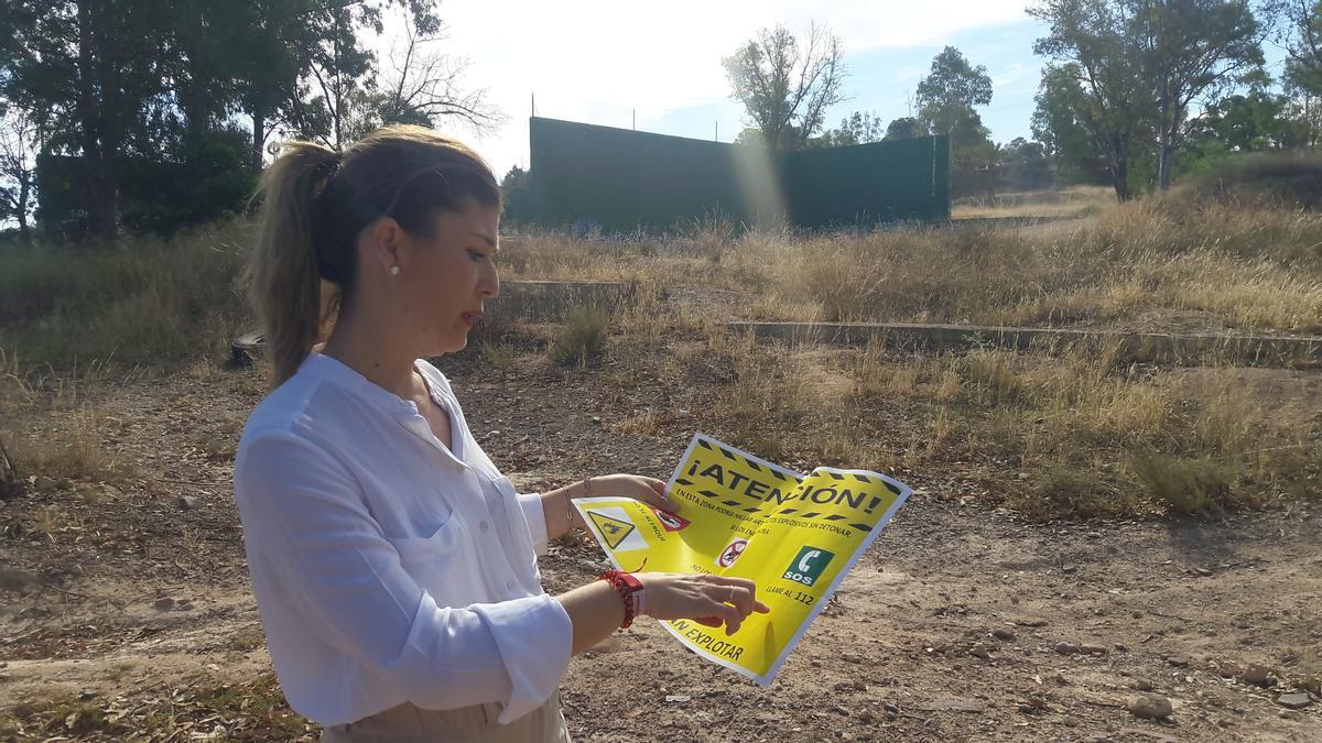 La edil del PP Rosa María Medina con un cartel de advertencia.