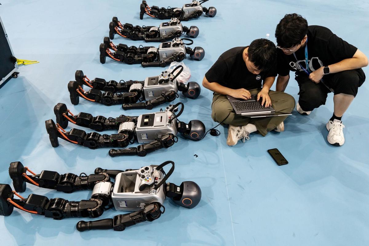 Técnicos programan robots humanoides antes de un partido de fútbol durante los Juegos Mundiales de Robots Humanoides en Pekín, China, el viernes 15 de agosto de 2025. El evento se celebra hasta el 17 de agosto. Fotógrafo: Qilai Shen/Bloomberg
