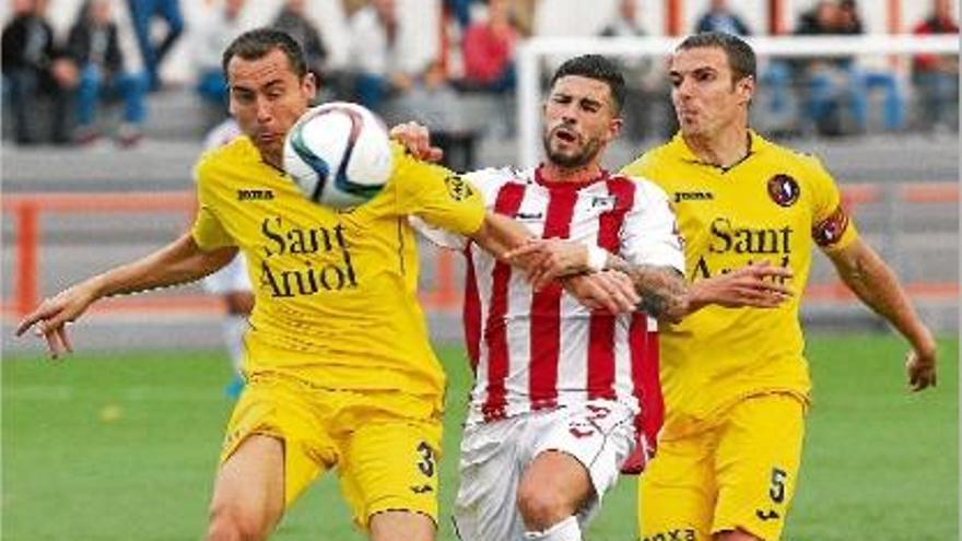 Vallho i Rojas intenten frenar un jugador de l&#039;Huracán en la derrota dels garrotxins a Torrent (2-0).