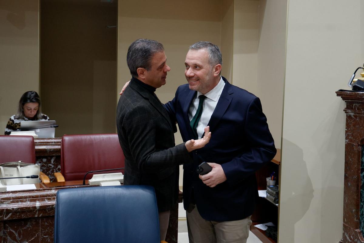 El portavoz del PP en la Asamblea, Joaquín Segado (d), saluda al portavoz del Gobierno regional, Marcos Ortuño.