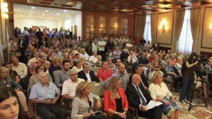 A la izquierda, los asistentes al acto institucional en el salón de plenos. A la derecha, los concejales del PP, solos en los escaños ante la ausencia de PSPV-PSOE y Compromís.
