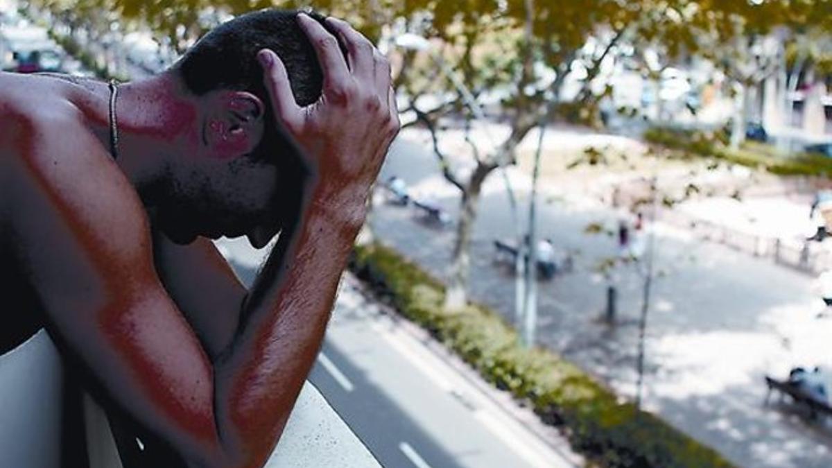 Un joven, en un balcón ante una calle de Barcelona.