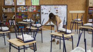 Una profesora mide la distancia de separación en un aula.