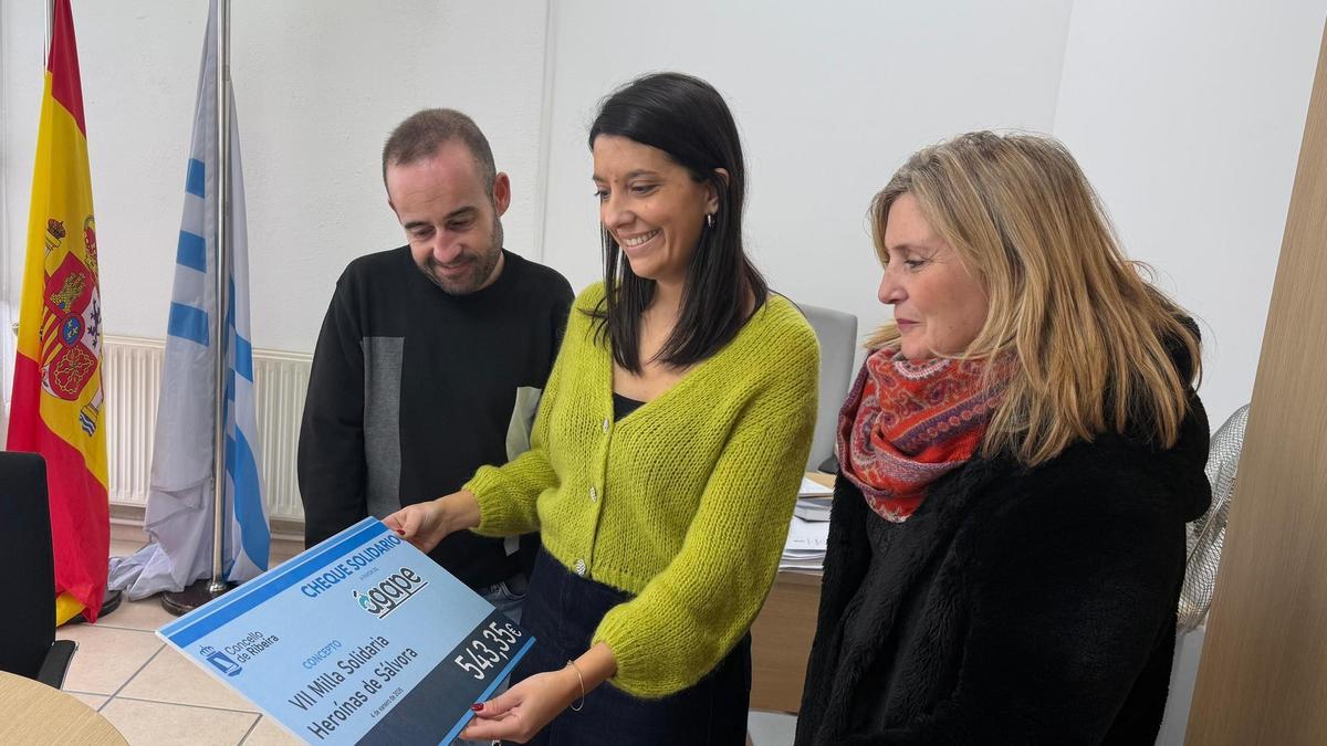 Álex Vidal e María Sampedro entregando o cheque a Ana Ruth Arnoso.