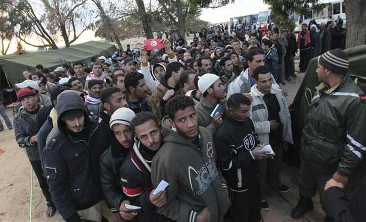 Refugiats egipcis procedents de Líbia fan cua davant un hospital militar de campanya en la frontera de Ras Khedir. Aquí s’ha desplegat personal de la Creu Roja tunisiana i de l’Alta Comissaria de Nacions Unides per als Refugiats (ACNUR) per atendre sobre el terreny les necessitats dels nouvinguts. Refugiats egipcis procedents de Líbia fan cua davant un hospital militar de campanya en la frontera de Ras Khedir. Aquí s’ha desplegat personal de la Creu Roja tunisiana i de l’Alta Comissaria de Nacions Unides per als Refugiats (ACNUR) per atendre sobre el terreny les necessitats dels nouvinguts.