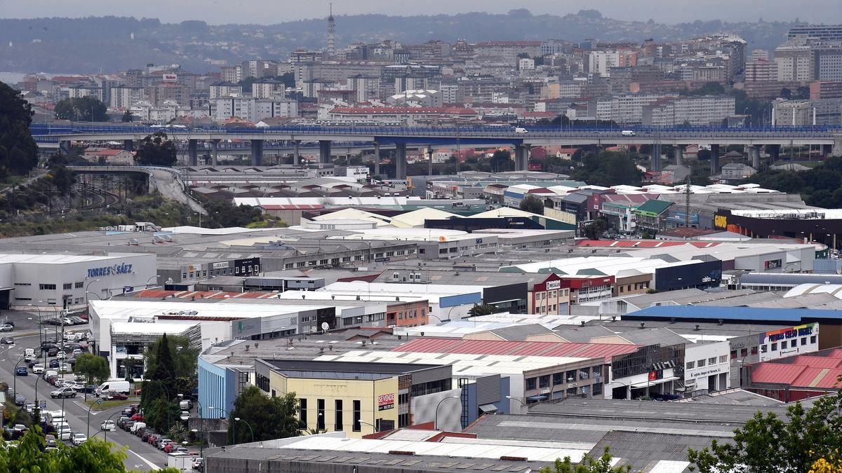 Naves del polígono coruñés de Pocomaco, con la ciudad de A Coruña al fondo. / Víctor Echave