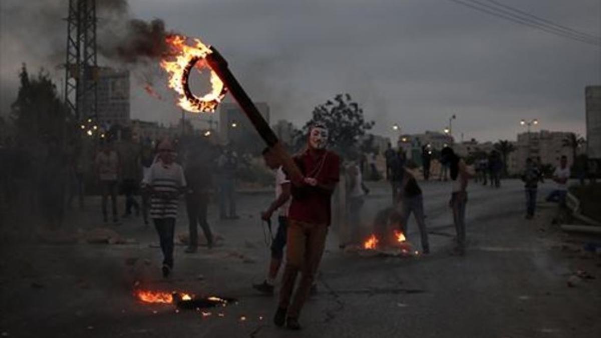 Jóvenes palestinos queman neumáticos en unos choques con soldados.