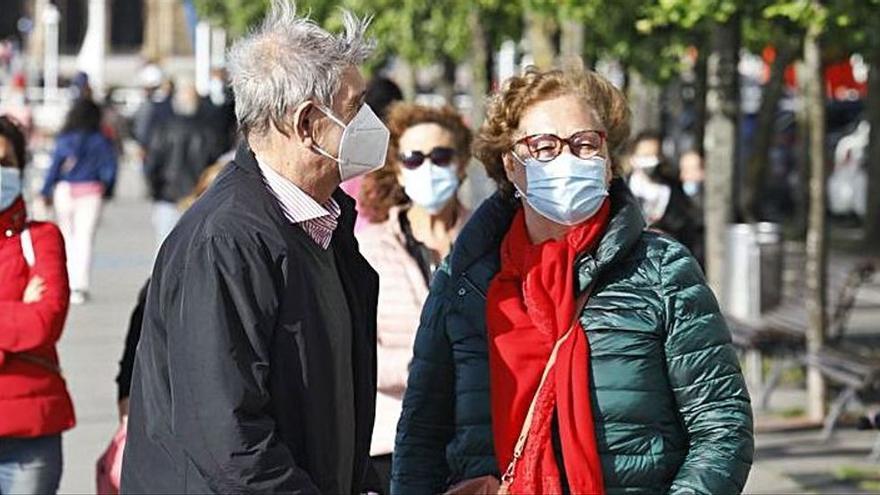 Paseantes con mascarilla, ayer, en Gijón