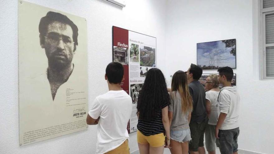 Un grupo de jóvenes se detiene en la lectura del panel sobre la etapa de Alejo en Flechas; a la izquierda una gran fotografía del poeta.