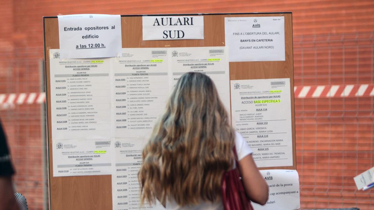 Una mujer comprueba las listas para una oposición celebrada en València.