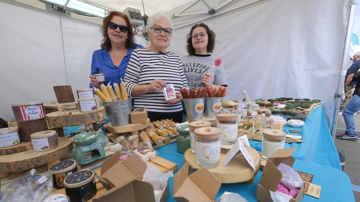 Madre, abuela e hija en un puesto de artesanía de velas.