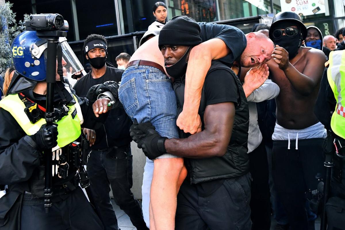Patrick Hutchinson, a protester, carries a suspected far-right counter-protester who was injured, to safety, near Waterloo station during a Black Lives Matter protest following the death of George Floyd in Minneapolis police custody, in London, Britain, June 13, 2020. REUTERS/Dylan Martinez     TPX IMAGES OF THE DAY     SEARCH INJURED COUNTER-PROTESTER FOR THIS STORY. SEARCH WIDER IMAGE FOR ALL STORIES.