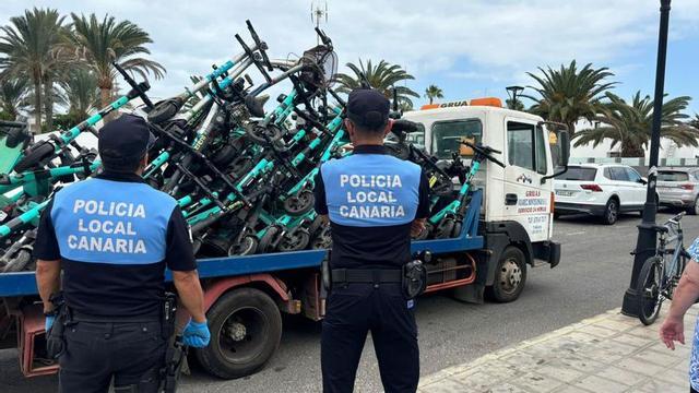 Dos agentes de la Policía Local de La Oliva observan las patinetas eléctricas retiradas de las calles de Corralejo. | | LP/DLP