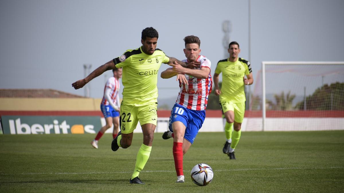 Carlos López, del Don Benito, disputa el balón ante Benji, del Ceuta.