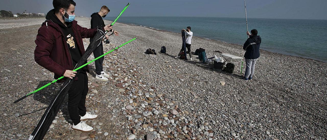 Varios vecinos, ayer, en la playa de Corinto, donde se aprecia el gran escalón existente hasta llegar a la orilla. | DANIEL TORTAJADA