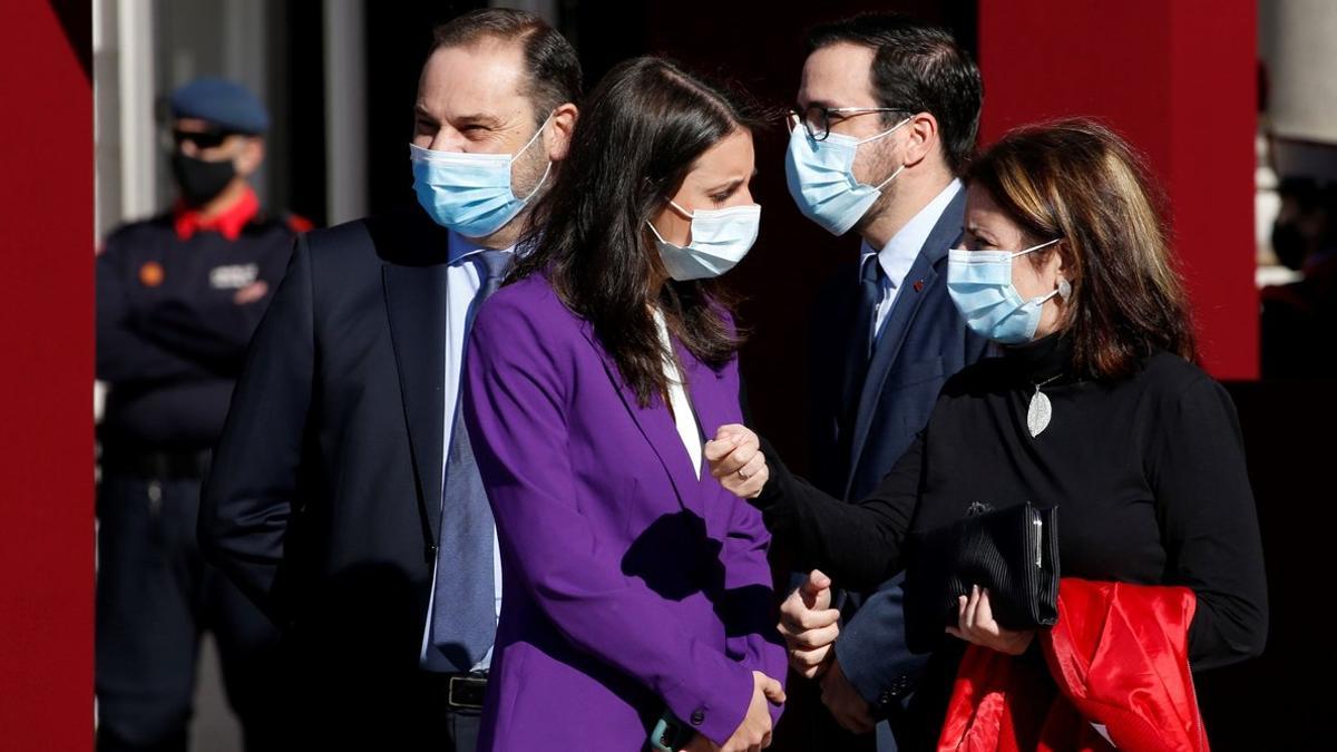 La portavoz socialista, Adriana Lastra, charla con la titular de Igualdad, Irene Montero, ante los ministros José Luis Ábalos y Alberto Garzón, este 12-O en la plaza de la Armería del Palacio Real.