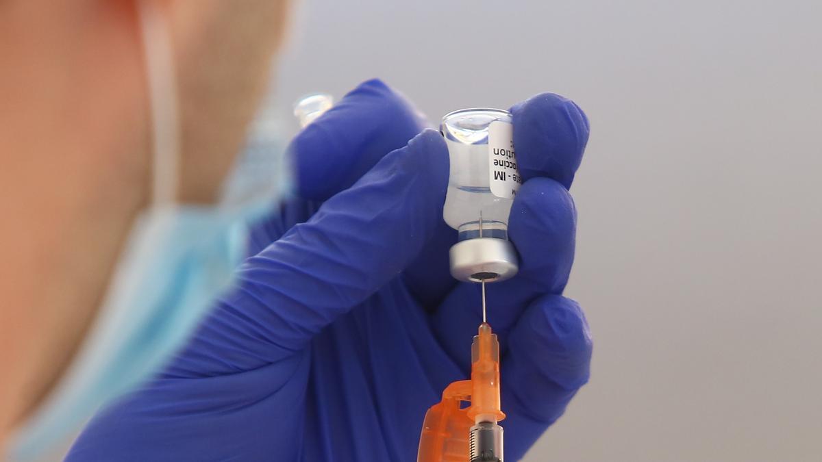 Una sanitaria prepara una vacuna contra el COVID.