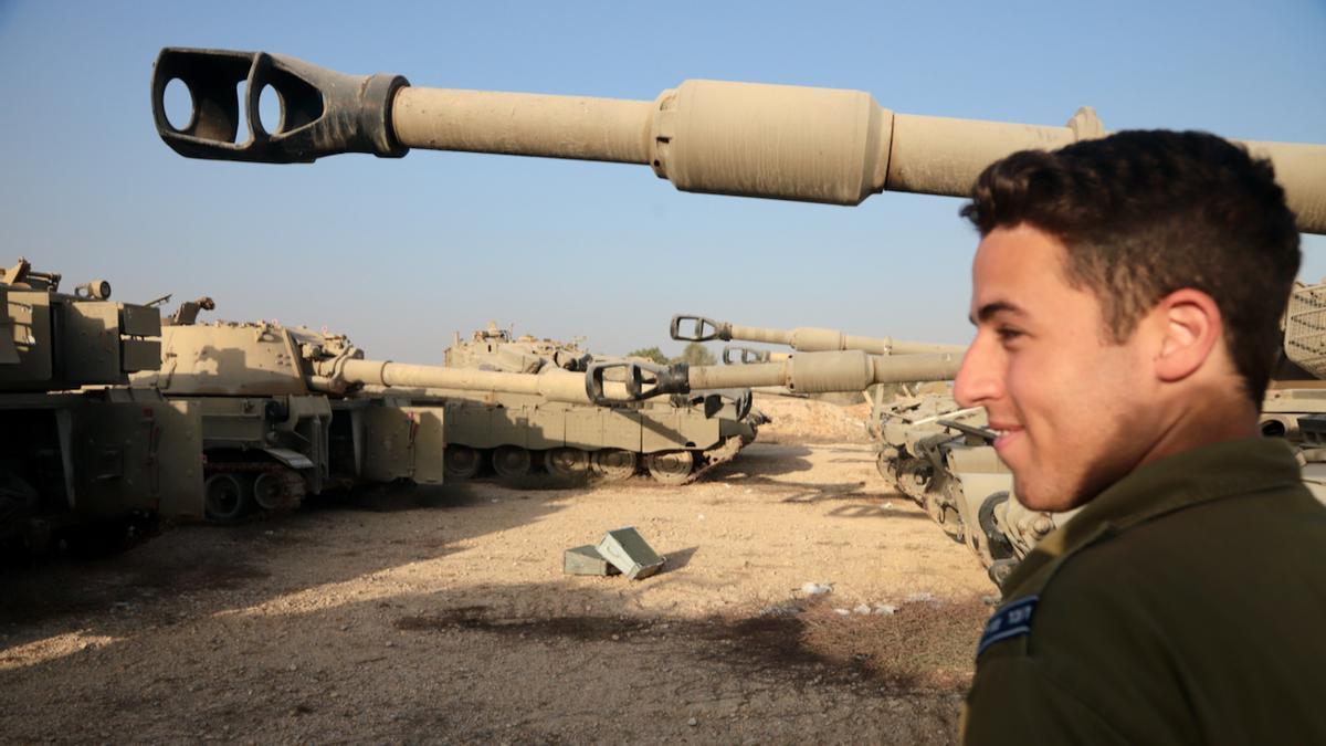 Un soldado pasea junto a carros de combate en la base militar israelí de Tzeelim