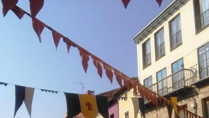 Vecinos pasean por la Plaza Mayor decorada al estilo medieval.