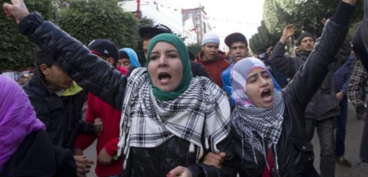 Dues dones criden consignes contra el Govern en una concentració davant del Ministeri de l’Interior, aquest dijous a Tunis.