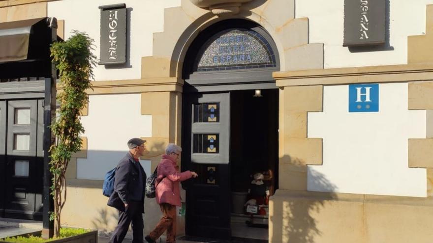 Dos visitantes, ayer, entrando a uno de los establecimientos hoteleros de Villaviciosa. | Alicia García-Ovies