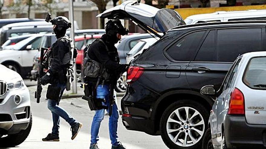 La policia inspecciona un cotxe prop del lloc on es va produir el tiroteig.