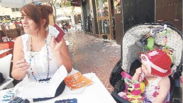 Jaycee Leigh, junto a su hija Rubie, muestra las tarjetas y documentos sanitarios.