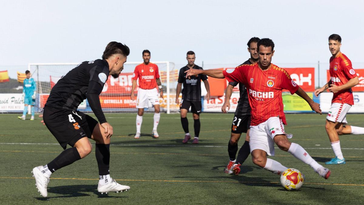 El mediocampista rojillo, Marcos, conduce el esférico entre dos jugadores del Torrent.