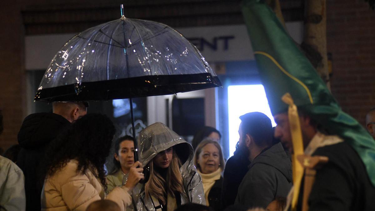 Personas con paraguas durante la procesión de Domingo de Ramos en Murcia