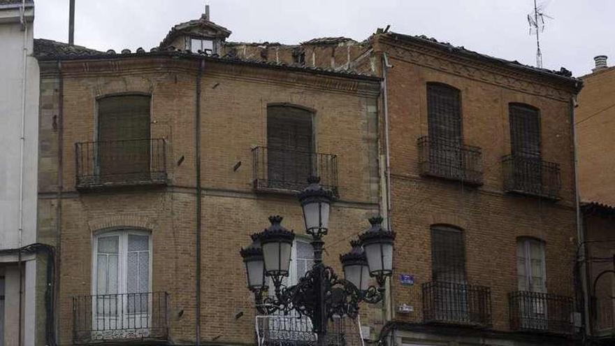 A la derecha, edificio en ruina de Cortes Leonesas. Es apreciable el estado de deterioro de la cubierta.