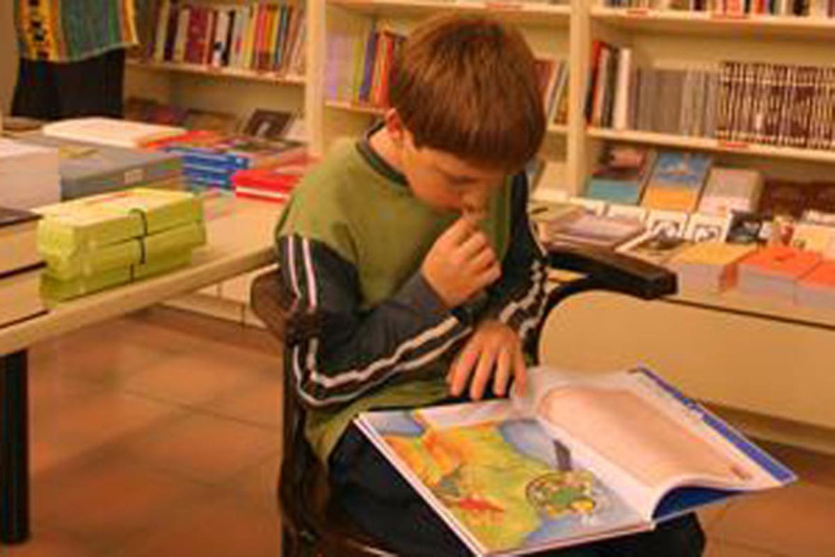 Un nen llegeix en una llibreria a Barcelona, el 2003.