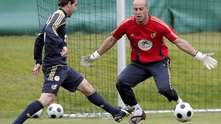 El defensa de la selección española Fernando Navarro , controla un balón ante el portero Pepe Reina.