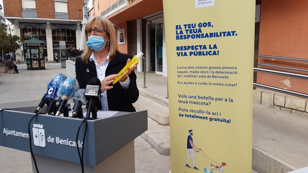 La concejala Filo Agut enseña cómo serán las botellas que repartirán a los vecinos, durante la presentación de la campaña, este martes.