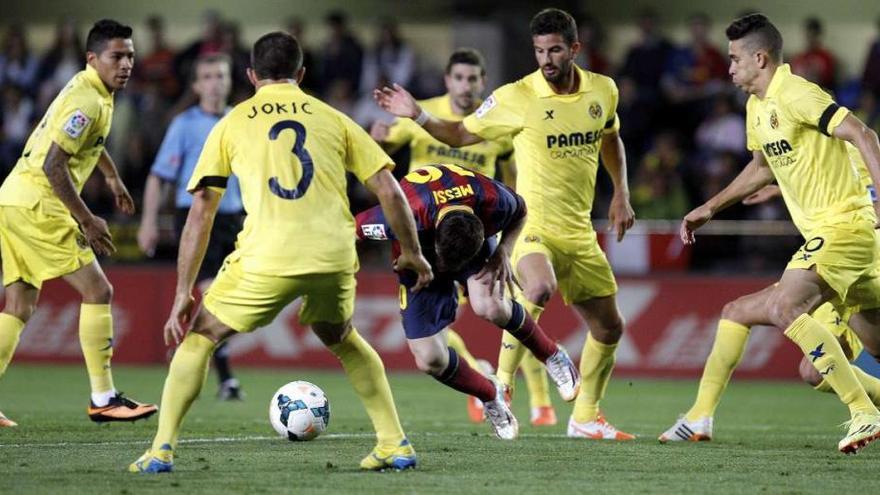 Messi se trastabilla, rodeado de jugadores del Villarreal, en el partido disputado ayer en El Madrigal. // Juan Carlos Cárdenas