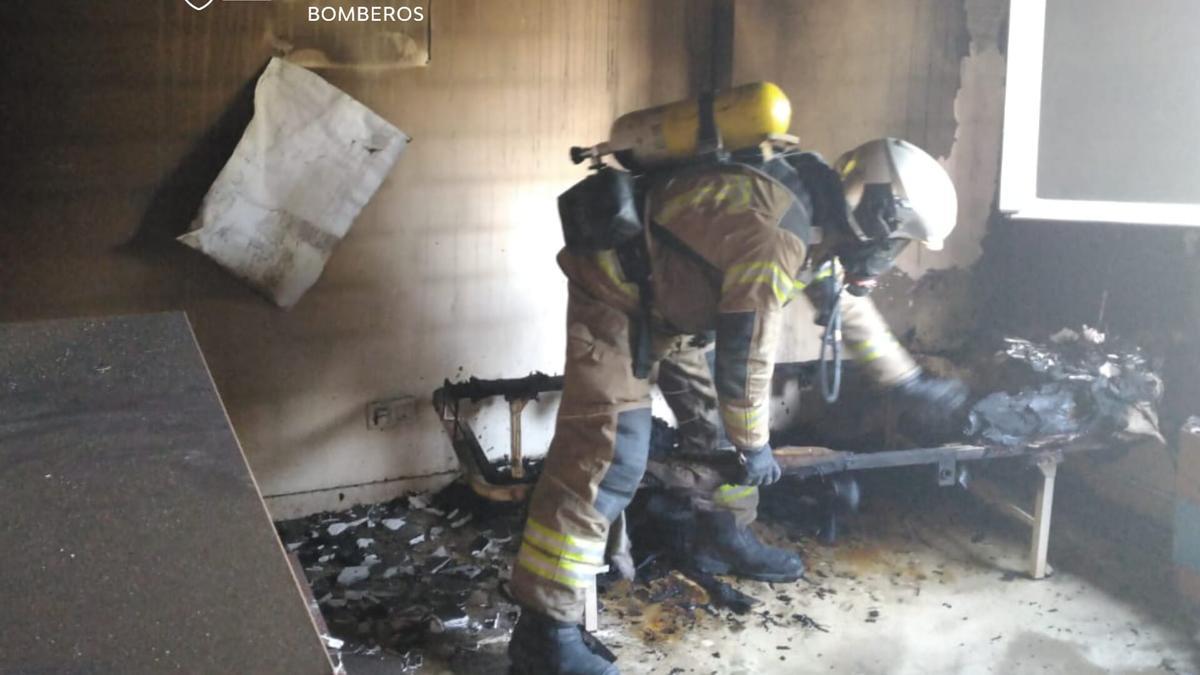 Un bombero de la DPZ trabaja en la habitación donde se inició el incendio.
