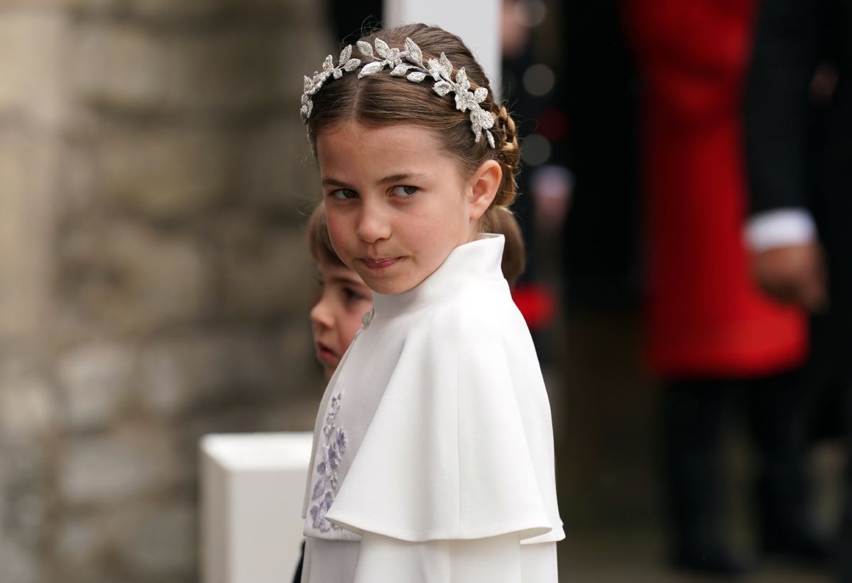 La princesa Charlotte con tiara y capa blanca.