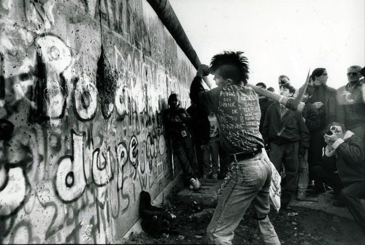 Un jóven punk rompiendo el Muro de Berlín.
