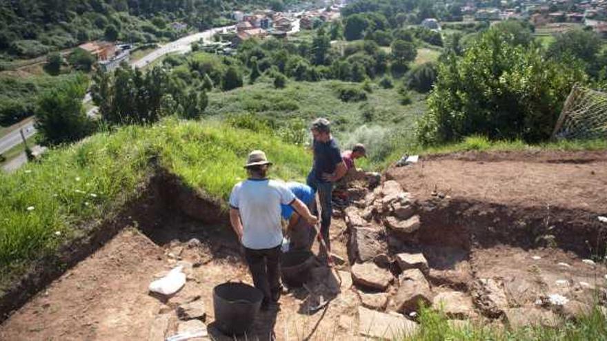 Iván Muñiz, de pie a la derecha, con miembros del equipo que trabaja en el castillo de Gauzón. Al fondo, Raíces Viejo.