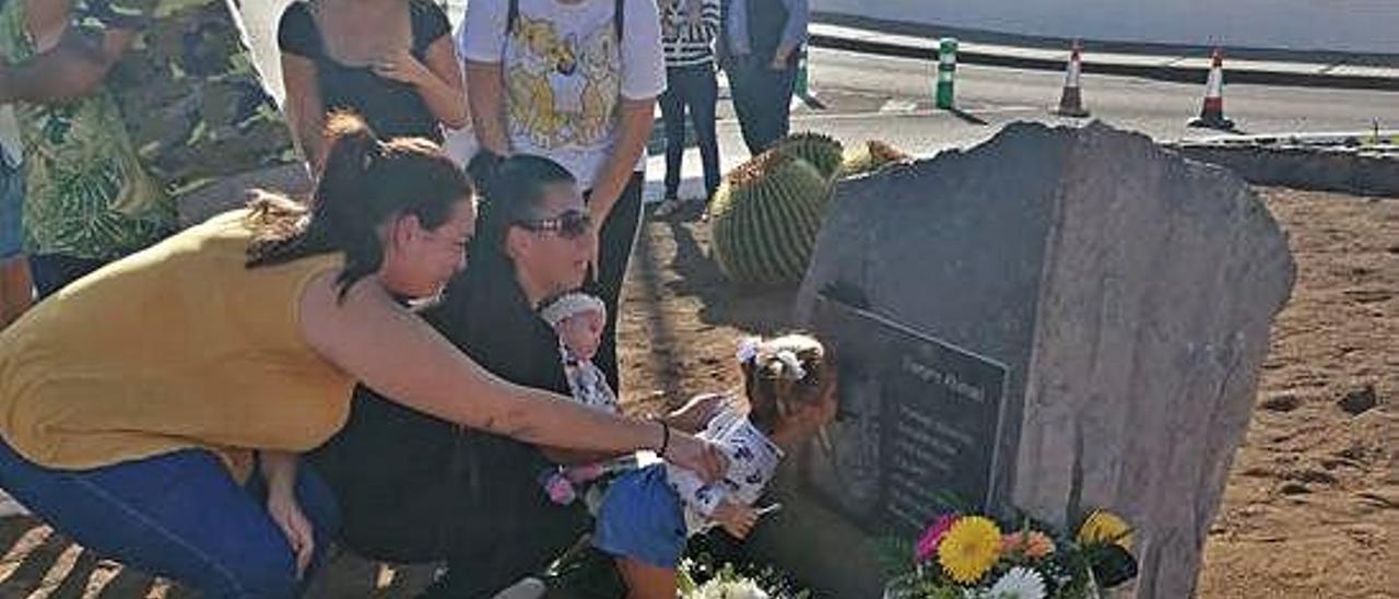 La madre del menor fallecido (en el centro, de negro), junto a familiares y la placa de conmemoración.