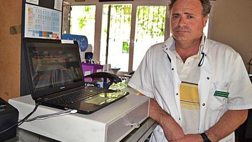 José Luis Barrón, posa ante el ordenador en la farmacia de Lubián.