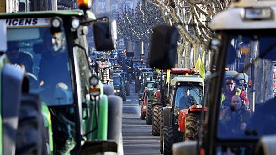 A dalt, centenars de tractors van omplir ahir la rambla Ferran, a Lleida. A baix, la plaça Sant Joan plena de gom a gom.
