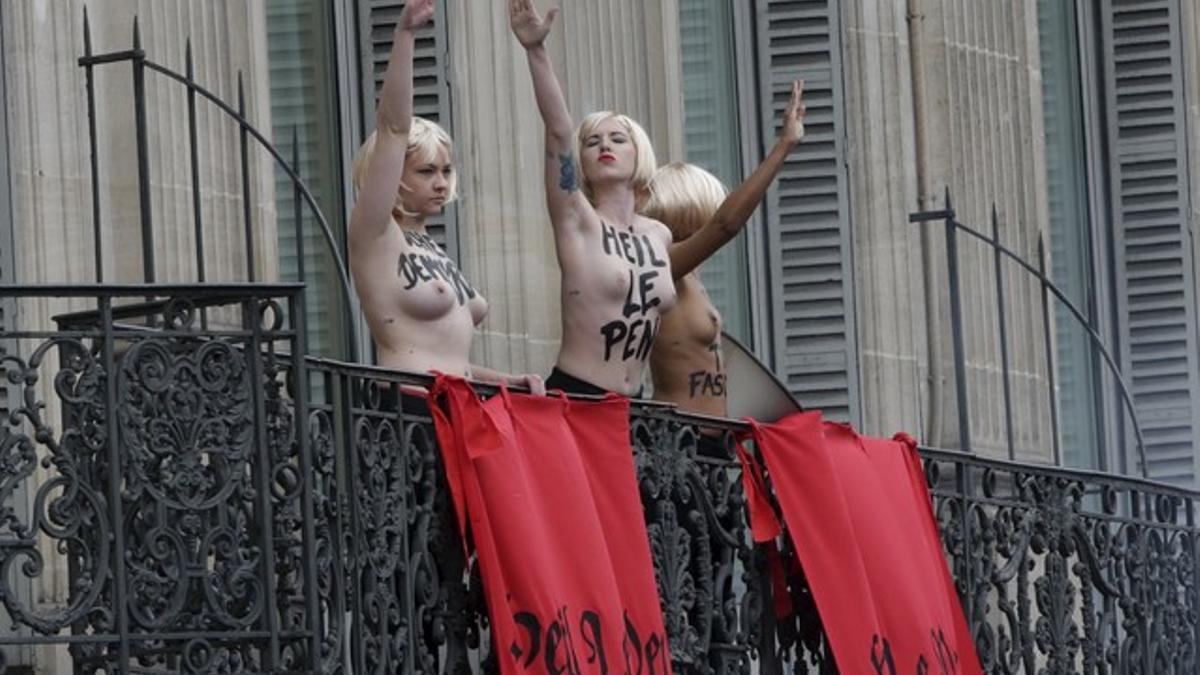 Activistas de Femen hacen el saludo nazi frente al lugar donde Marine Le Pen daba un discurso, este viernes en París.