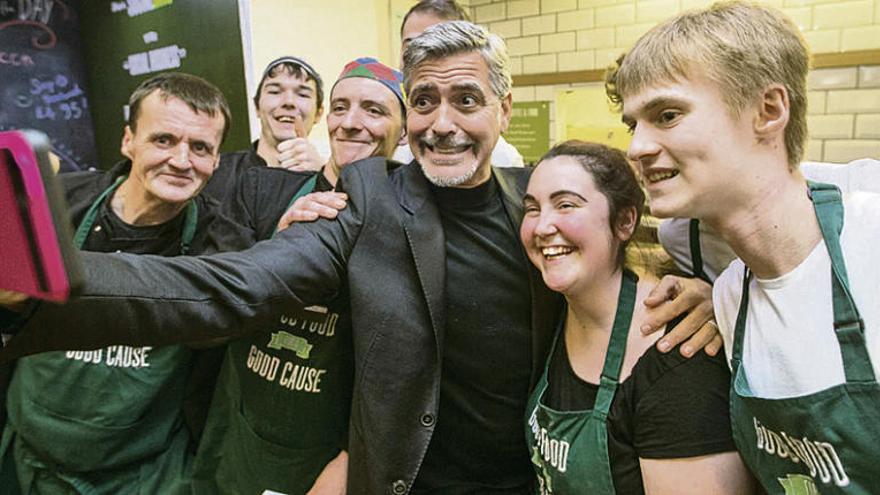 Clooney se hace un &quot;selfie&quot; con empleados del café. // Efe