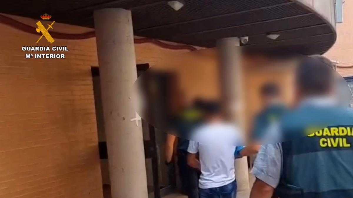 Uno de los detenidos es trasladado por la Guardia Civil.