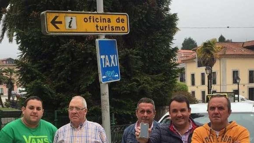 Celso Álvarez, José Huerta, Gerardo Fernández, Julio Álvarez, mostrando la página web en el móvil, y Francisco José Díaz, ayer, en la parada de taxi de Pravia.