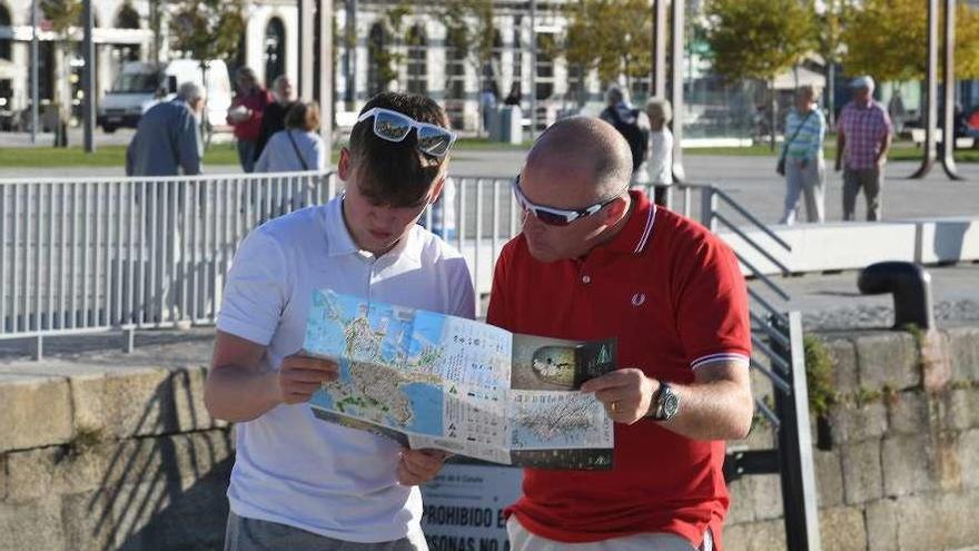 Dos turistas observan un mapa de la ciudad coruñesa.