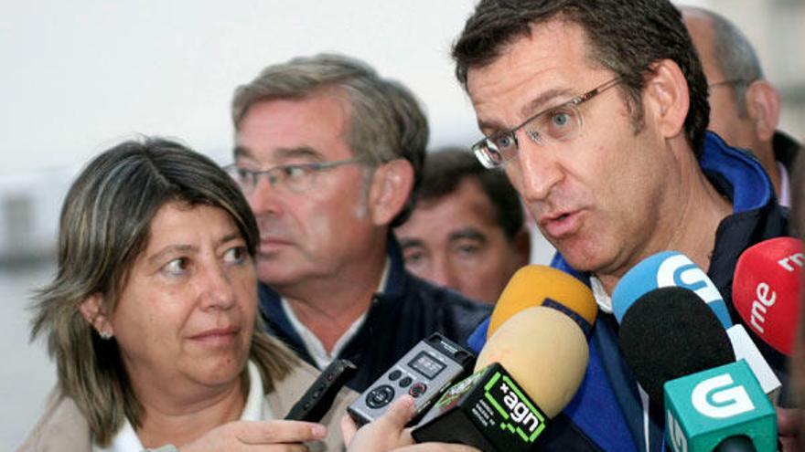 El presidente de la Xunta, Alberto Núñez Feijóo, acompañado de la responsable de Mar, Rosa Quintana, hace declaraciones a los medios de comunicación durante la visita que realizó hoy a la zona de venta de la lonja de Burela (Lugo). // EFE