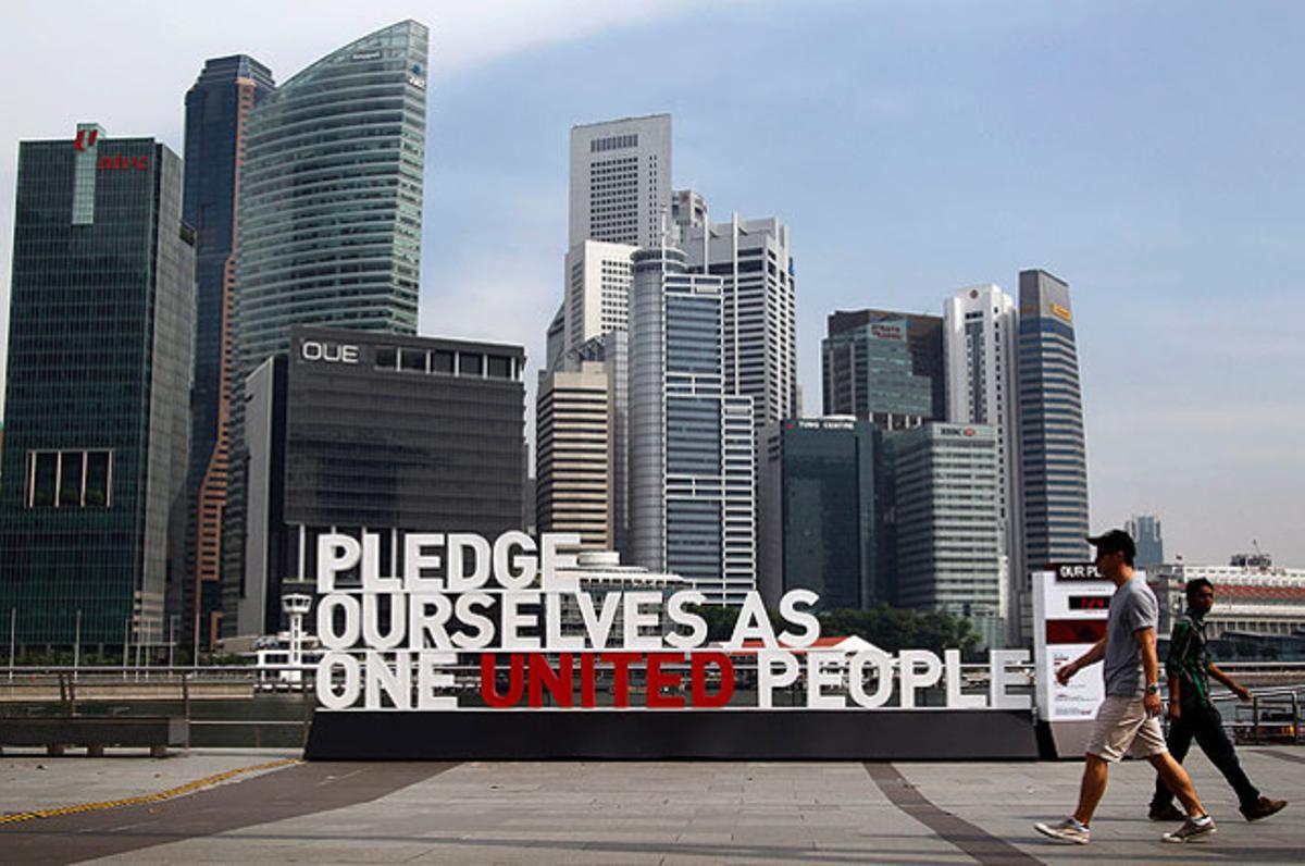 Una cita de la promesa nacional de Singapur en què es pot llegir ens comprometem com un poble unit, instal·lada com una escultura a la capital del país.